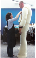 Behind-the-scenes photo of the full-body foam suit built around actors who play the giants. Notice that the hands are oversized gloves fitted over the actor's hands.