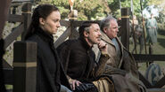 Petyr "Littlefinger" Baelish, his ward "Alayne" (Sansa Stark), and Lord Yohn Royce observe Lord Robin Arryn fighting.