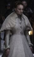 Sansa's wedding dress when she is married to Ramsay Bolton in Season 5's "Unbowed, Unbent, Unbroken". Note the heavy feathering on the shoulders, echoing the Stark-style heavy furs, and her mother's Tully fish-sigil clasps.