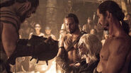 Qotho restrains Viserys Targaryen as Drogo kills him in "A Golden Crown".