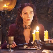 Melisandre dines with Stannis and Selyse in "The Lion and the Rose".