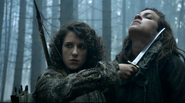 Meera Reed holding a knife to Osha's neck in "Dark Wings, Dark Words".