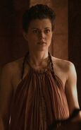 Commoners and servants dress more simply, with loose sleeveless and backless tunics bound to a ring around the collar (better suited to the warm weather in King's Landing). Notice that this handmaiden is copying Cersei's hairstyle.