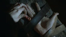 Ramsay Snow tira a pele do dedo mindinho de Theon Greyjoy.