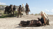 Qotho looks on as Daenerys Targaryen tends to the injured Drogo after he falls from his horse in "Baelor".