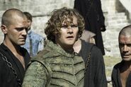 Loras is arrested by the Faith Militant. Note the color of his sparring outfit: in Season 5, the Tyrell's costumes have changed from the mild teal seen in earlier seasons to bold green as a visual assertion of their power.