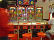 A Spin to Win quadruple machine at an arcade while a boy is playing it on the fourth one (right)