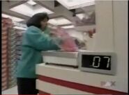 A Team #2 contestant measuring candy in 2001. Note that the scale is on the other side of the end cap, and that the readout is on the side of the scale. (Though not pictured here, there is also a readout on the end cap.)