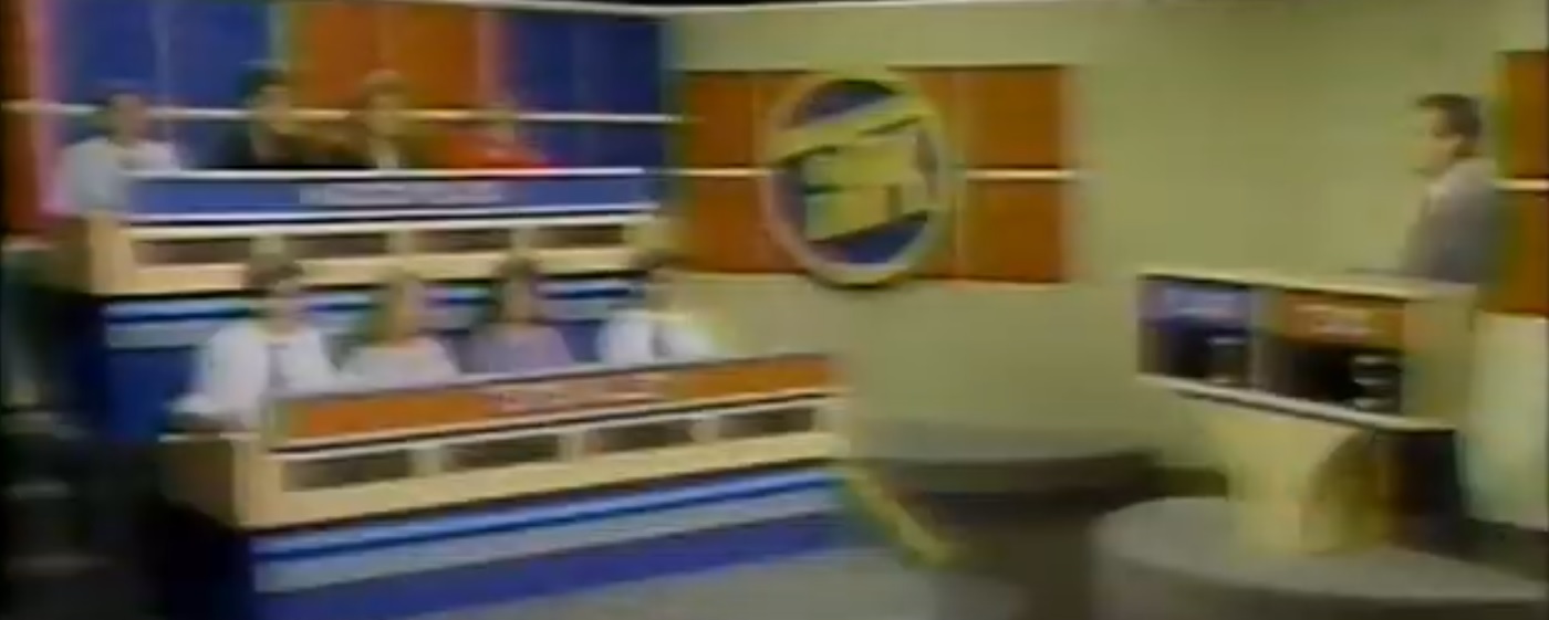 The set for "In the Know" on WOSU TV34 in Columbus, Ohio, from Season 23 to Season 28 (October 2, 1987-May 6, 1993) featured a beige wall with blue and red terracotta titles and the ITK logo on the wall next to the host and contestants. The student and host podiums were also beige to match the walls, and the carpet on the student podiums was lighter gray. Host Bill Schiffman's hair was still black, and the blue and red rectangles had the student team names. The ITK logo can be seen on the beige wall with red terracotta tiles can be seen behind Schiffman. As before, host Bill Schiffman leaves his podium at the end of each episode, and walks over to the student podiums to chat with the contestants. After the chat, the camera still zoomed in for a close-up of the ITK logo as the credits rolled.