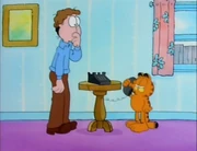 Phone: Jon watches in surprise when Garfield meows into the phone.