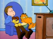 Translation: Garfield, Odie, and Jon relax on the couch in front of the TV after eating too much.