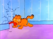 Licking: Garfield grimaces as Odie gives him a big slurp from a mousehole.
