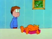 Boring: Jon watches a feather as Garfield blows it.