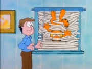 Blind: Garfield is tangled in Venetian blinds, much to Jon's surprise.