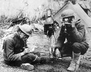 "St. Pole, France, June 12, 1918 - Two Kansas City Correspondents, Mr. Higgins and Mr. Breede, inspecting a gas-proof telephone exchange." A famous photo of AEF Signal Corps Personnel field-testing the Petit Model Tissot Mask. Proving the U.S. continued to use the scant amounts of Tissot Masks available well into 1918.