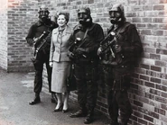 SAS personnel standing beside Margaret Thatcher while wearing S6 gas masks