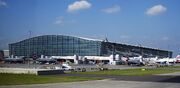 Planes congregate by a building.