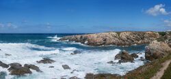 Photo of surf breaking on rocky shore