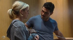 Nathan tries to unlock Maxie's cuff with a paperclip but they stare at each other instead