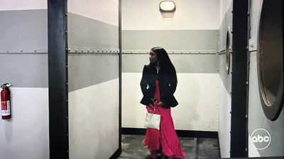 Trina sneaks down a hallway (2023)