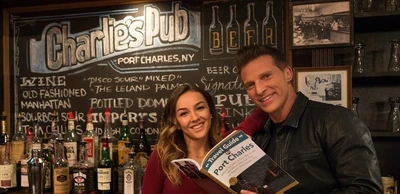 Kristina Corinthos-Davis and Jason Morgan read the Travel Guide to Port Charles at the Pub