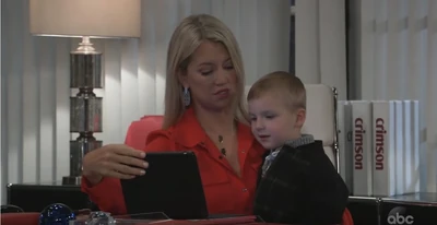 Grandmother and grandson playing at her office desk (2021)