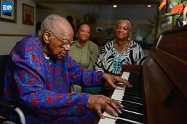 Smith plays the piano at the Packwood Rest Home in Somerset on her 106th birthday in 2013, along with her cousins Joan Forde (left) and Julia Durham (right).