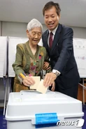 Moon Dae-jeon in June 2018, aged 109, voting with her son Jeong Won-bok.