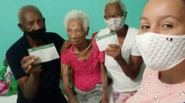 Erminia Lopes dos Santos (center) in February 2021, after being vaccinated against covid-19.