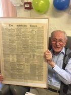 Tinniswood at the age of 106, with a 1912 copy of The Times newspaper which was printed on the day he was born