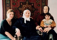 Dzhukalaeva at the claimed age of 123 in 2004, with her daughter Am, her granddaughter Aset, and her great-granddaughter Dasho.