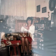 Piano (age Mid 60s or Early 70s) opening one of her presents on Christmas Day sometime in the 1980s.