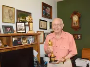 Berkos (aged 99; almost 100) at home on 1 August 2022, holding his Academy Award for sound effects in the 1975 movie “The Hindenburg”