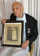 George Johnson (aged 111) holding a framed photo with his mother.