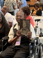 In September 2019, holding a photo of himself as a young man