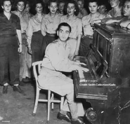 Berlin (front, age 56) plays the piano for the United States Army Womens Army Corps at their mess hall, Hollandia, Dutch New Guinea, on Christmas Eve, 1944.