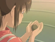 Chihiro hält einen Kräuter-Kloß.