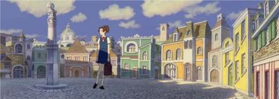 Haru steht am Platz mit kleinen Häusern.