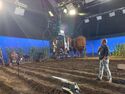 Benoit Richard and Mike Ambrose set up lighting on dirt field at Farmhouse studio set (Credit: Peter Markowski)