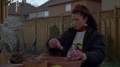 Vlcsnap-2025-09-25-21h40m00s976.png (1.76 MB) Pam works on the potted plants. Note the wood cover on the left which belong to the wooden planters on the terrace and the birdhouse in the tree