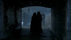 Vlcsnap-2025-10-21-14h19m49s807.png (695 KB) The sisters walk through a passage (E) in a building toward to court yard (J). In the background, the fenced entryway with the main gate way in the back.