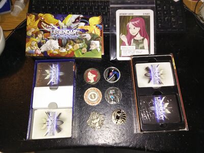 The Legendary Showdown: Machines & Magic game is displayed along with the game box cover art and some stretch goal rewards from the campaign including oversized cards and "challenge coins".