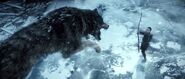 Atreus fires his arrow at a charging wolf.