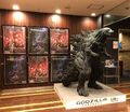 Images of a set of framed posters and the Godzilla Earth statue.