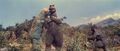 Godzilla grabs Gabara's arm and throws him onto the ground