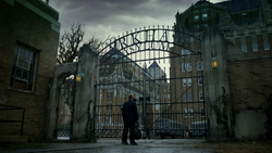 Jim waiting outside the Arkham Asylum gate