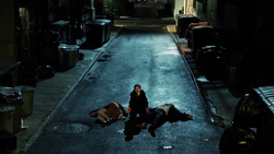 Bruce kneeling at his parent's dead bodies screaming.