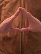 Gus makes a triangle hand gesture