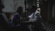 Meredith and Alex using ophthalmology equipment to test her eyesight.