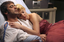 Izzie lying with a deceased Denny.